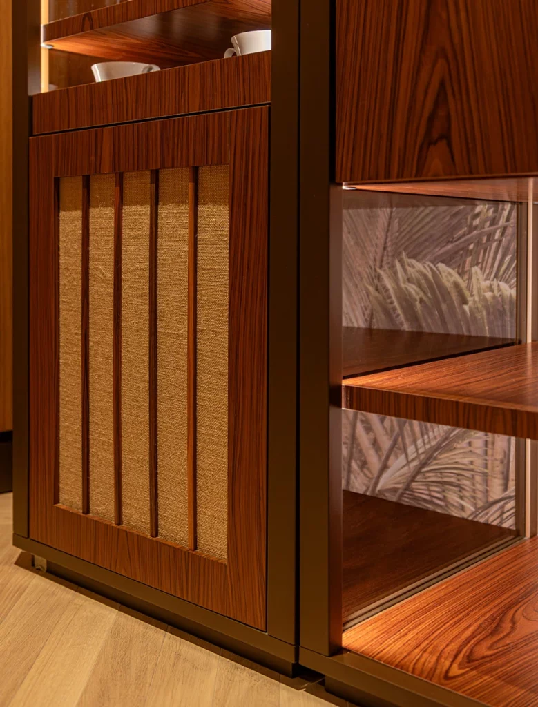 Dettaglio mobile contenitore in legno con inserti tessili e ripiani illuminati a LED