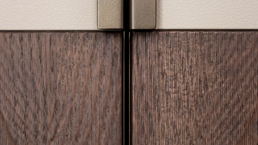 Dettaglio giunzione tra pelle e legno con cerniera in ottone, esempio di lavorazione artigianale di alta falegnameria Antonacci