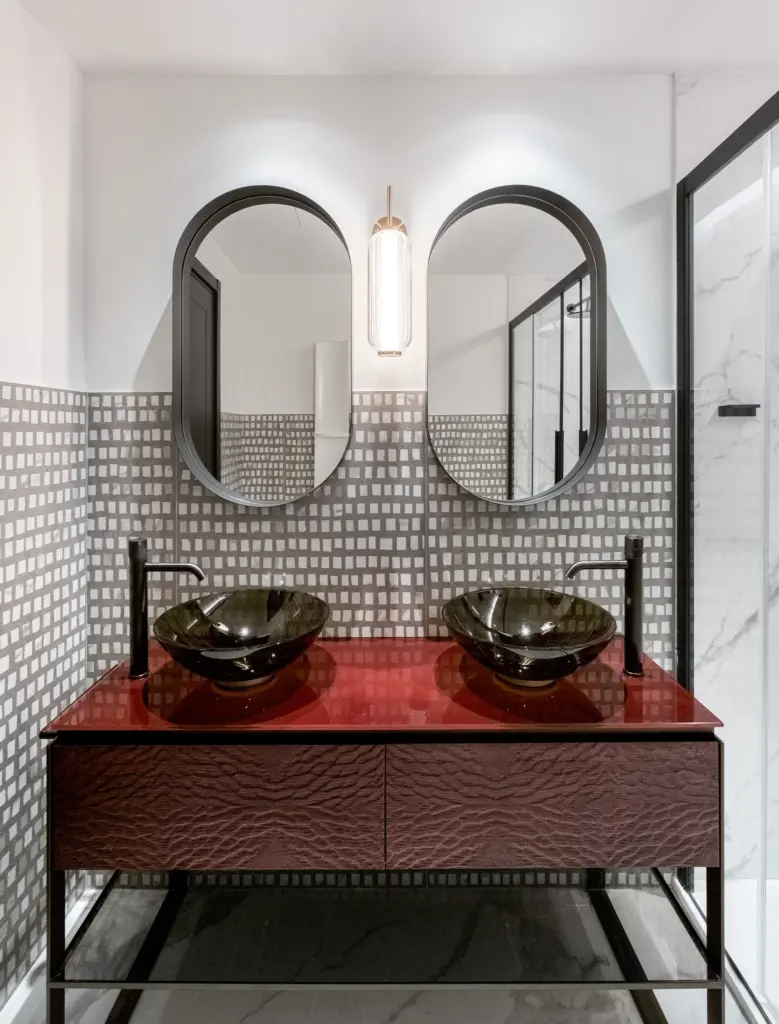 Bagno di Palazzo Rota con doppio lavabo in vetro, piano laccato rosso e specchi ovali, arredi su misura di falegnameria Antonacci.