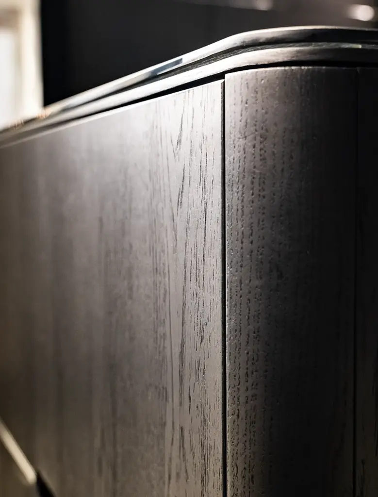 Primo piano di armadiature su misura in rovere tinto scuro con profili metallici e bordi arrotondati, lavorazione artigianale Antonacci Falegnamerie per Ciaogym